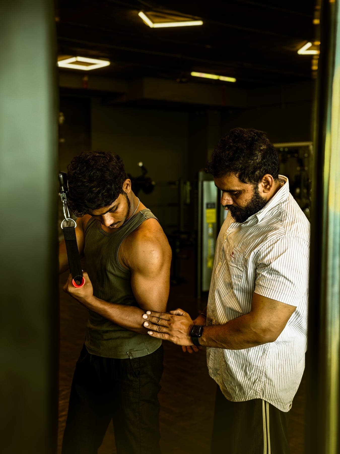 Trainer guiding a member through an assisted dip machine exercise